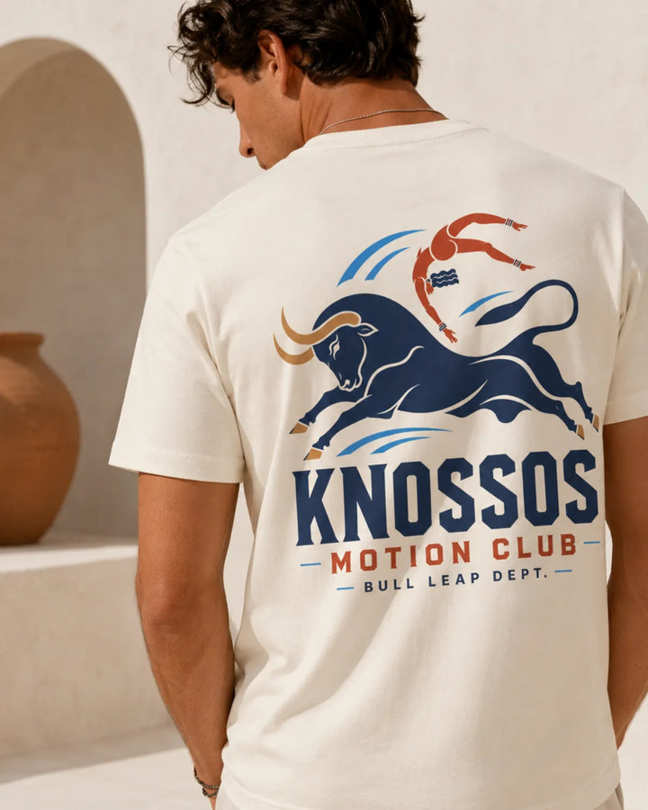 Man wearing a natural t-shirt with a bull and swimmer graphic and 'Knossos Motion Club' text
