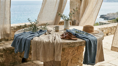 lightweight apparel and accessories styled on a sunlit terrace table near the sea