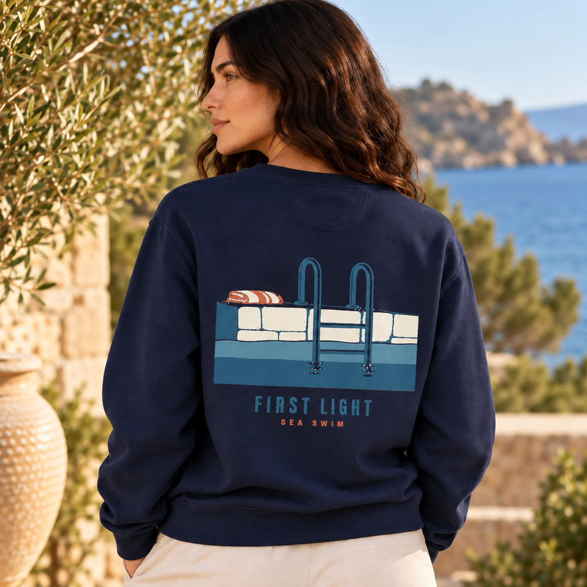 TP HERO: First Light Sea Swim True Navy sweatshirt close-up back design on model with Mediterranean sea ladder artwork