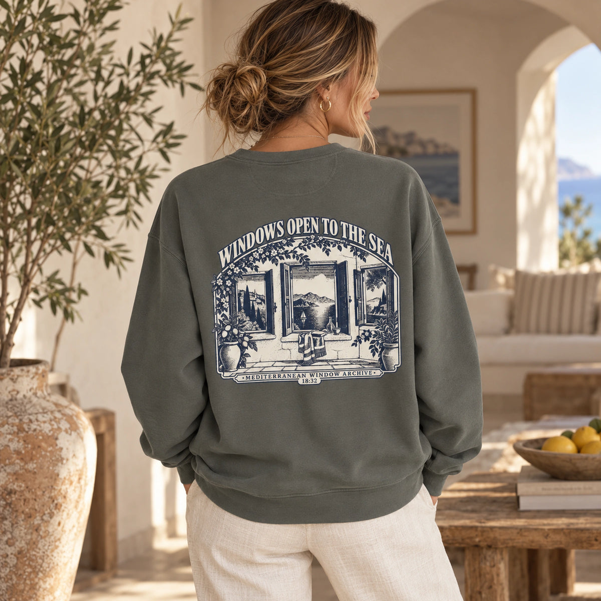 TP HERO: Windows Open to the Sea Pepper Comfort Colors 1566 sweatshirt shown from the back with large Mediterranean window graphic.
