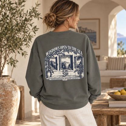 TP HERO: Windows Open to the Sea Pepper Comfort Colors 1566 sweatshirt shown from the back with large Mediterranean window graphic.