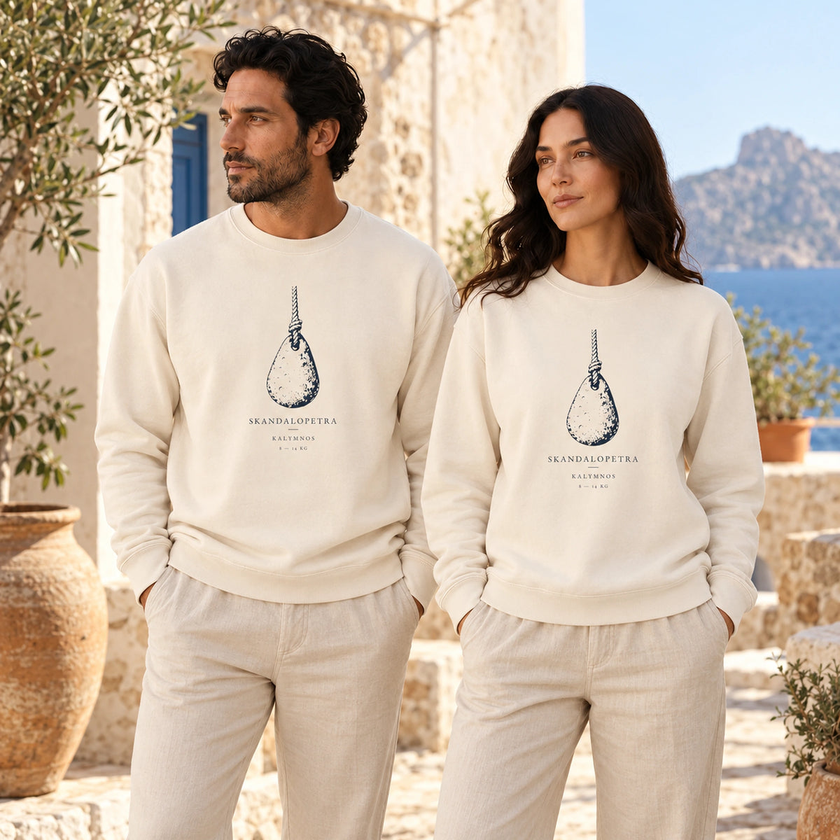 Two models wearing Skandalopetra Ivory lightweight crewnecks in a Mediterranean courtyard