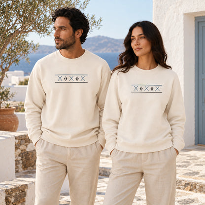 Two models wearing Ivory Tinos Dovecote Geometry crewnecks in a Mediterranean courtyard