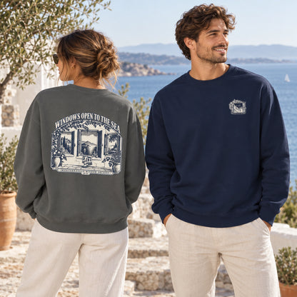 Windows Open to the Sea Pepper and True Navy Comfort Colors 1566 sweatshirts in a Mediterranean coastal lifestyle scene.
