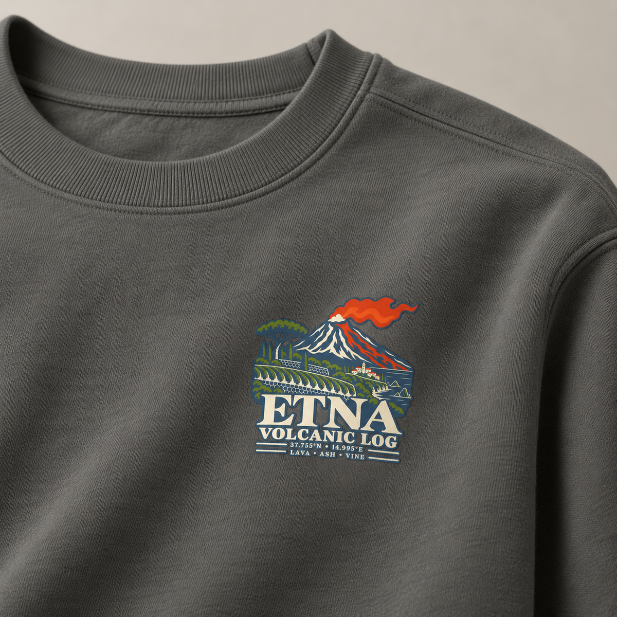 Close-up of the Etna Volcanic Log chest print on a Pepper garment-dyed Comfort Colors 1566 sweatshirt.