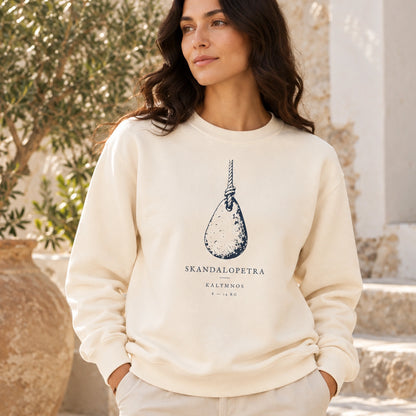 Close front view of female model wearing Skandalopetra Ivory lightweight crewneck in a Mediterranean courtyard
