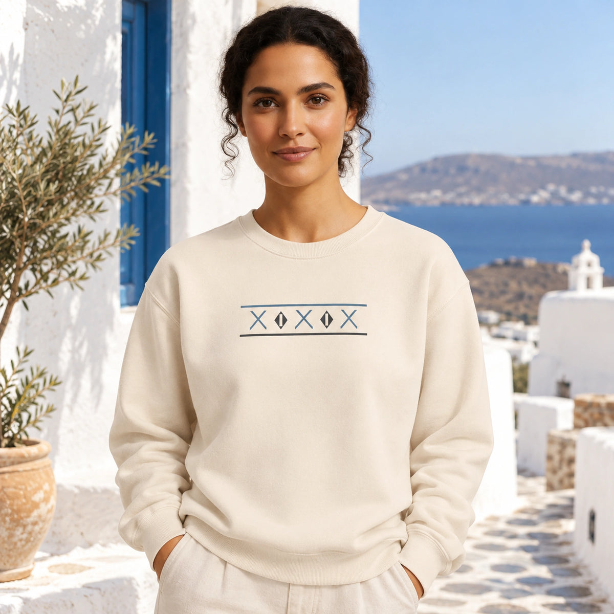 Close front view of female model wearing Ivory Tinos Dovecote Geometry sweatshirt in the Mediterranean