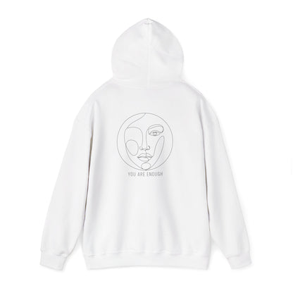 White hoodie with a face design and 'You Are Enough' text on a white background