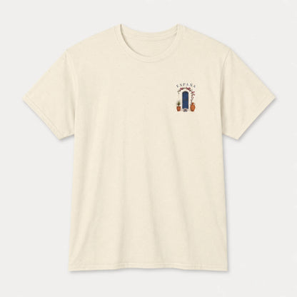 An off-white crewneck t-shirt with a small graphic on the left chest depicting a blue door, potted plants, and the text 'SUNNY DAY'.