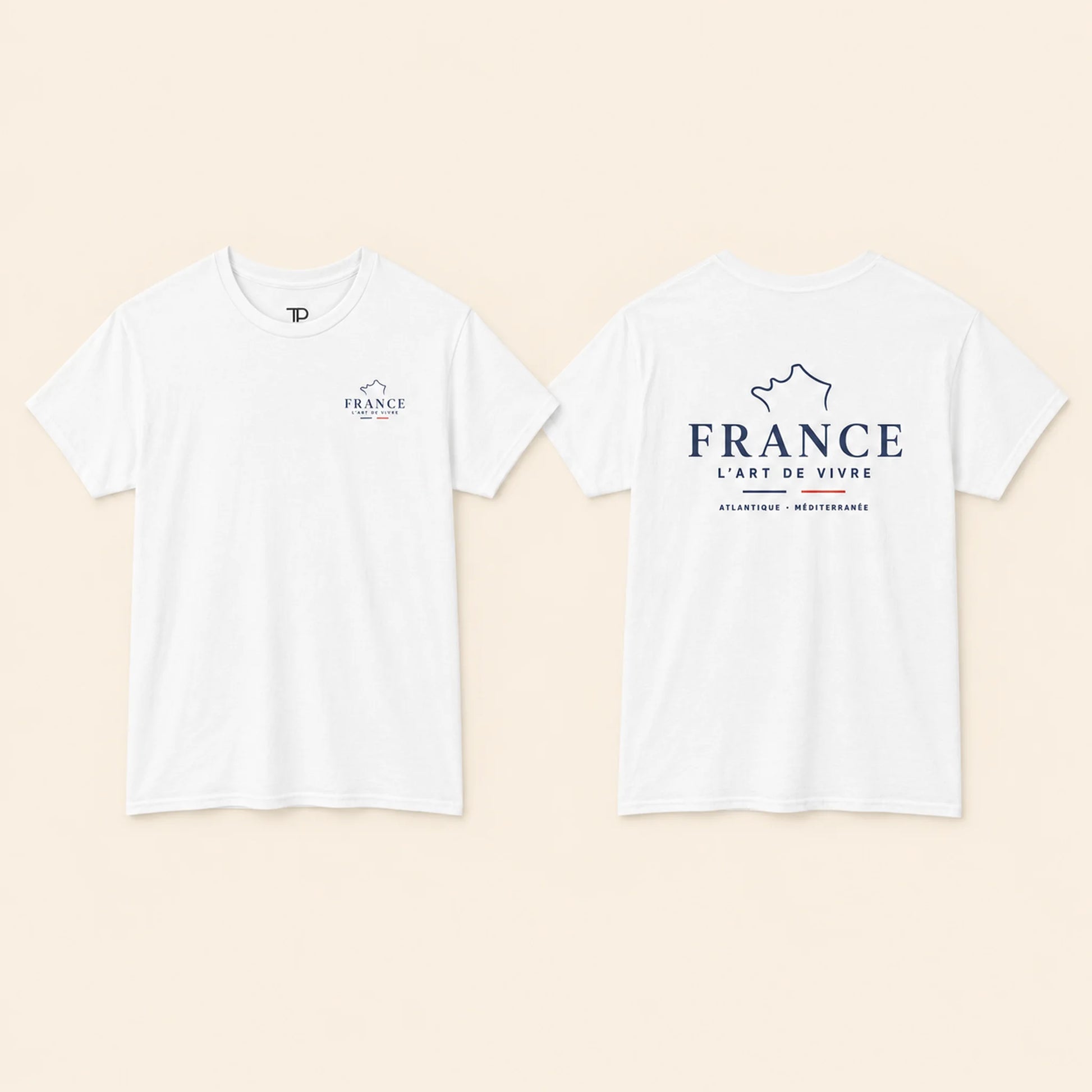 Two white short-sleeve T-shirts shown flat against a light beige background, displaying the front and back views. The front features a small navy blue logo on the left chest, and the back features a larger navy blue graphic with the text 'FRANCE L'ART DE VIVRE' and 'ATLANTIQUE - MEDITERRANEE'.