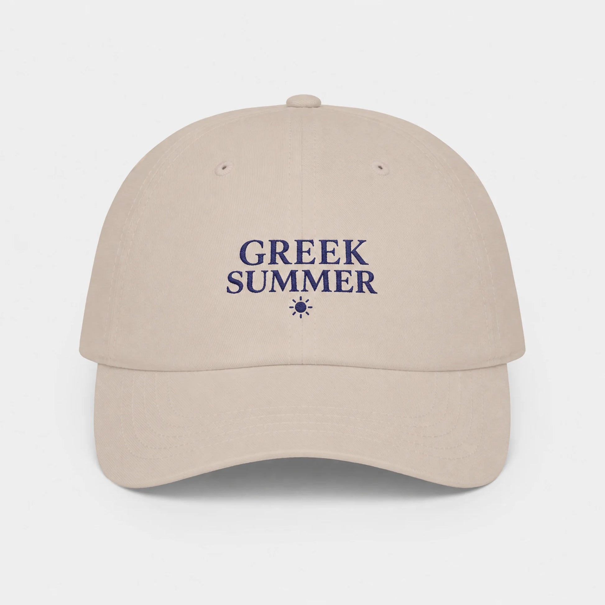 A stone baseball cap with 'GREEK SUMMER' embroidered in navy blue on the front, accompanied by a small sun icon, set against a light gray background.