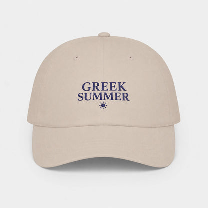 A stone baseball cap with 'GREEK SUMMER' embroidered in navy blue on the front, accompanied by a small sun icon, set against a light gray background.