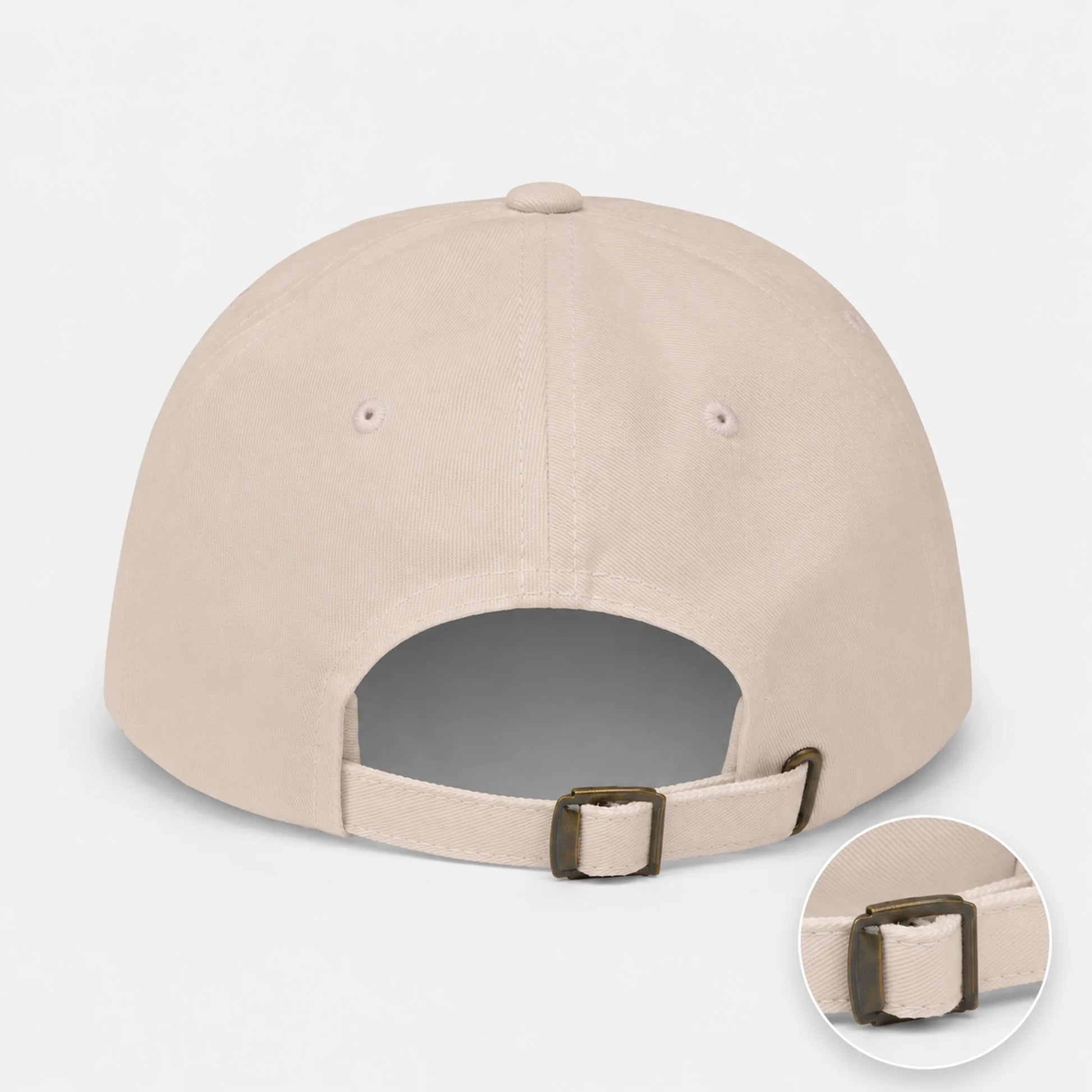 A stone baseball cap shown from the back, featuring an adjustable strap with a dark metal buckle and a circular inset detail of the buckle.