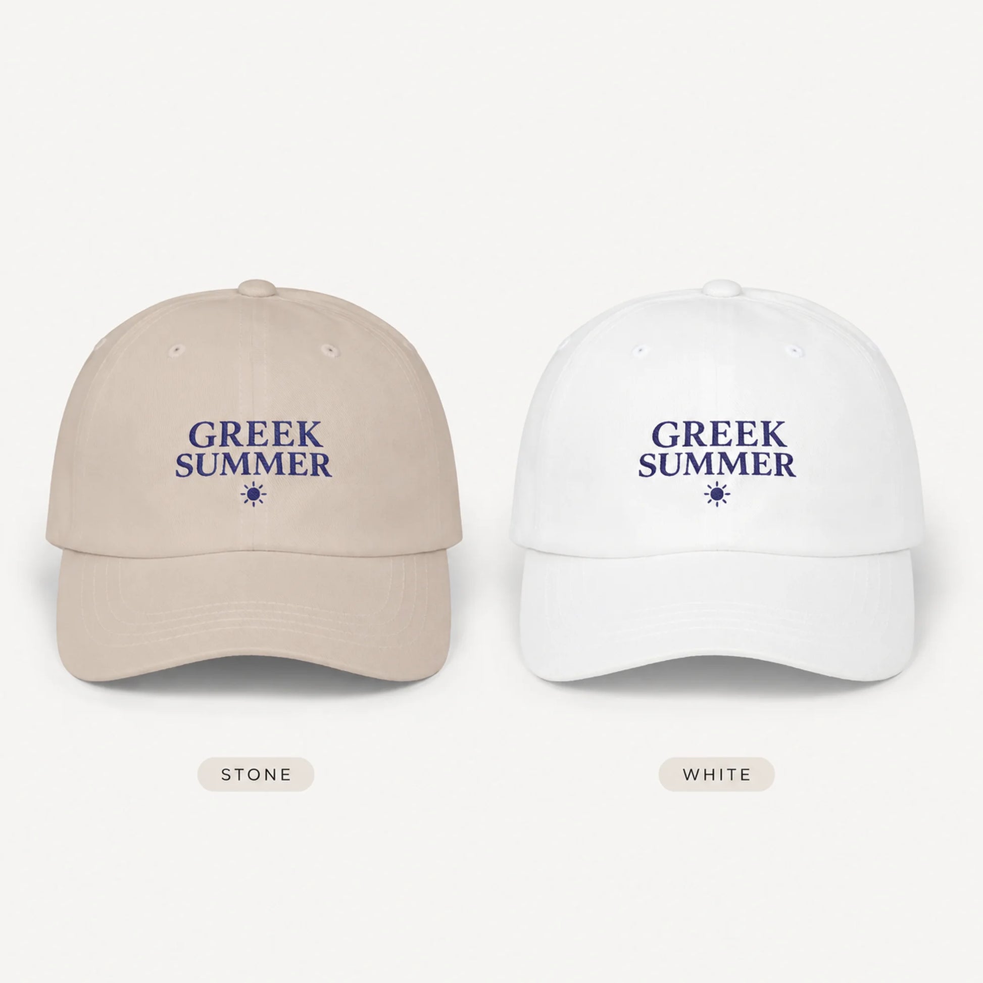 Two baseball caps shown side by side on a light gray background, labeled Stone and White. Each cap has the words “GREEK SUMMER” embroidered in navy blue above a small star icon.