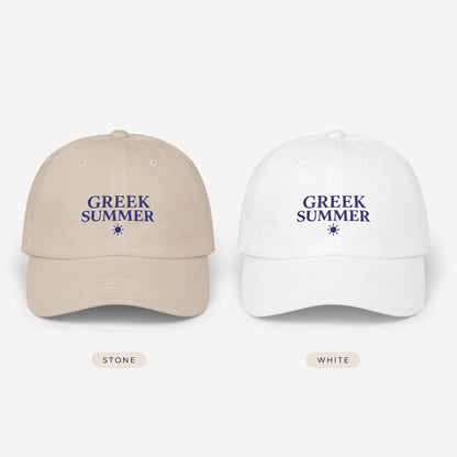 Two baseball caps shown side by side on a light gray background, labeled Stone and White. Each cap has the words “GREEK SUMMER” embroidered in navy blue above a small star icon.