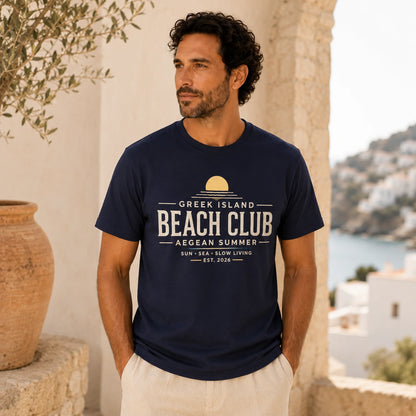 Man wearing a navy blue t-shirt with 'Greek Island Beach Club' text, standing in a scenic location.