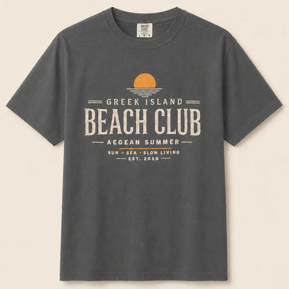 Gray t-shirt with 'Greek Island Beach Club' text and logo on a beige background