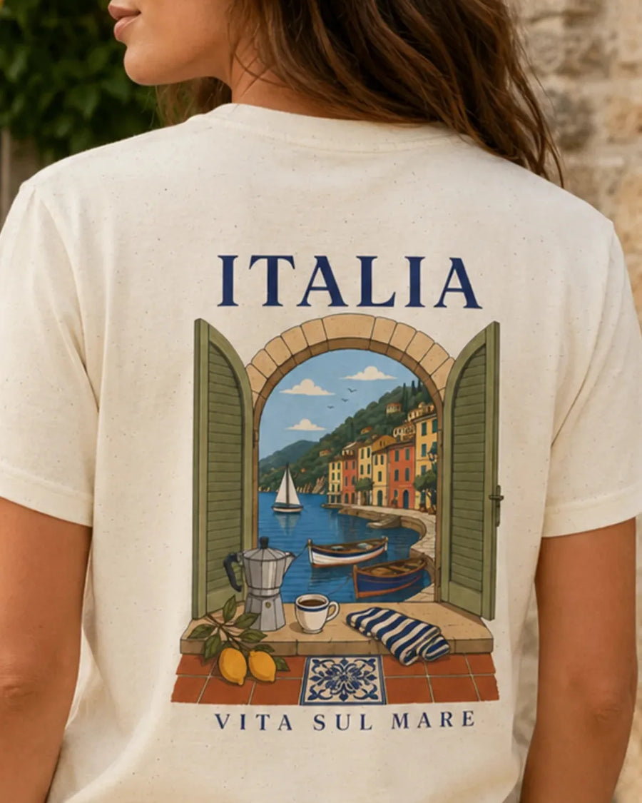 Adult model wearing the Natural ITALIA Vita Sul Mare unisex T-shirt with a small Italian-inspired left-chest print.