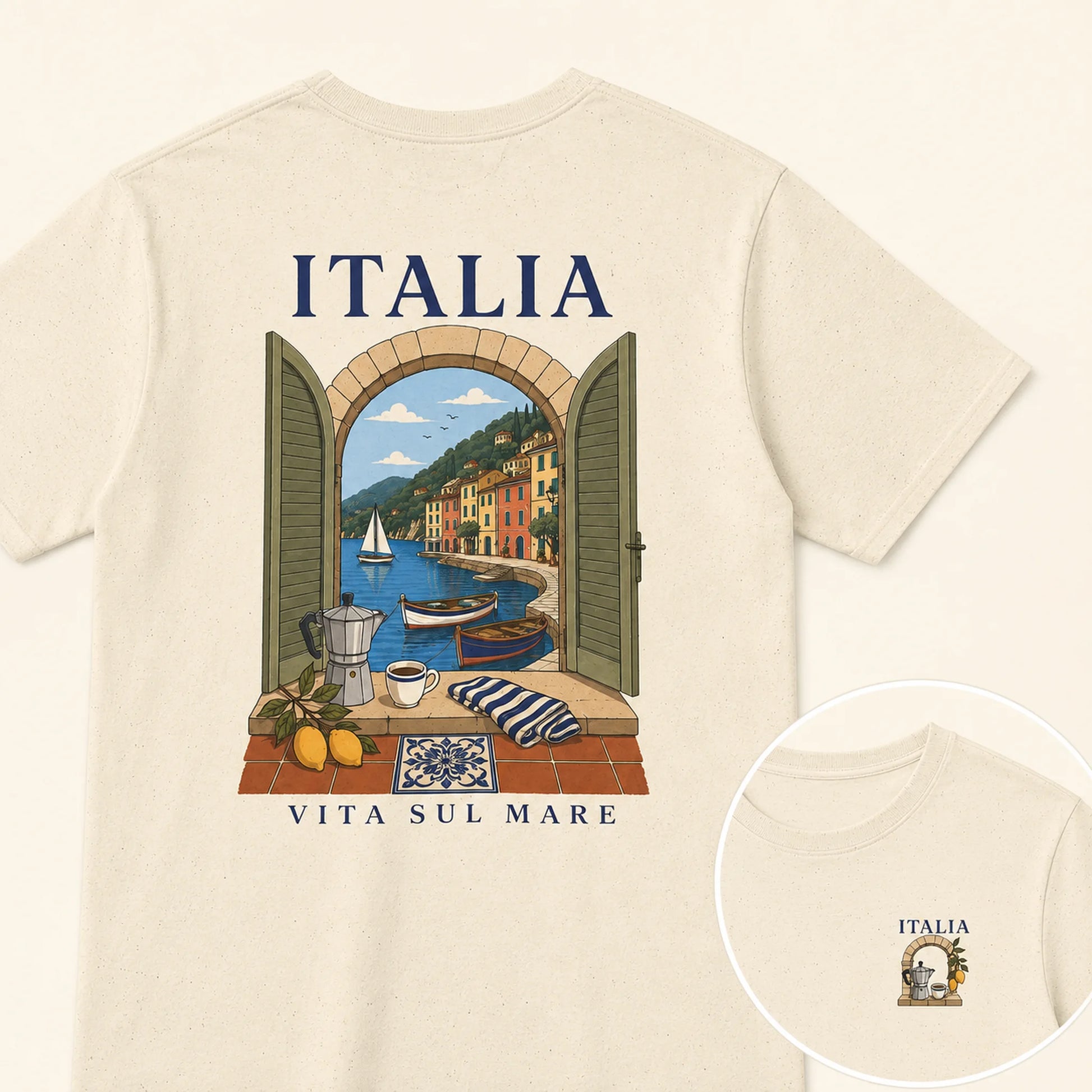 A cream-colored short-sleeve t-shirt shown from the back, featuring a colorful graphic print of an Italian coastal town seen through an open shutter window. The text 'ITALIA' is printed above the graphic, and 'VITA SUL MARE' is printed below.
