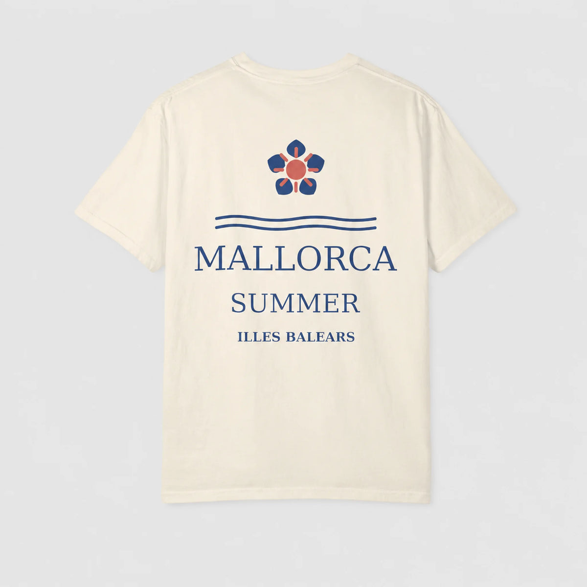 An off-white short-sleeve t-shirt with a graphic print on the back featuring a blue and orange flower, the text 'MALLORCA SUMMER ILLES BALEARS' in blue, and two blue horizontal lines, displayed on a light gray background.