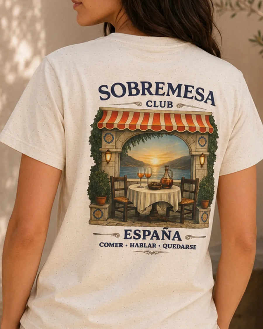 Back of the Natural Sobremesa Club España T-shirt with a Spanish café arch, coastal sunset and dinner table illustration.