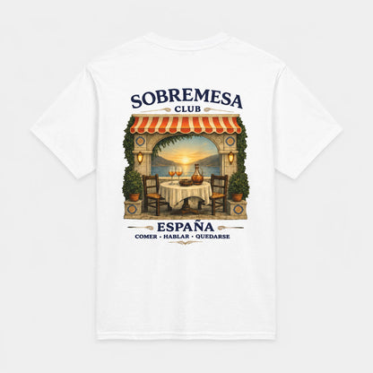 A white short-sleeve t-shirt with a graphic print on the front depicting a Spanish outdoor restaurant scene under a red and white striped awning, with the text 'SOBREMESA CLUB' and 'ESPAÑA COMER - HABLAR - QUEDARSE'.