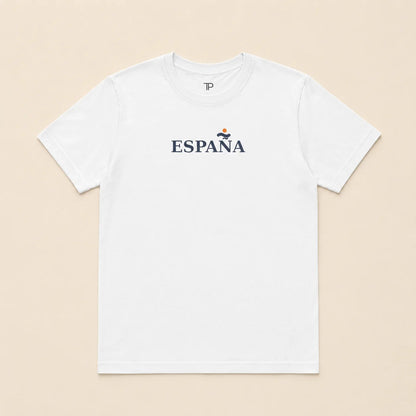 A white short-sleeve crewneck t-shirt with 'ESPANA' printed in navy blue across the chest, featuring a small red and yellow emblem above the text, laid flat on a light beige background.