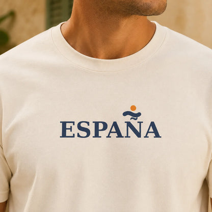 TP HERO: A close-up of a man wearing a cream-colored crewneck t-shirt with 'ESPAÑA' printed in navy blue across the chest, featuring a small orange sun and blue wave graphic above the text.