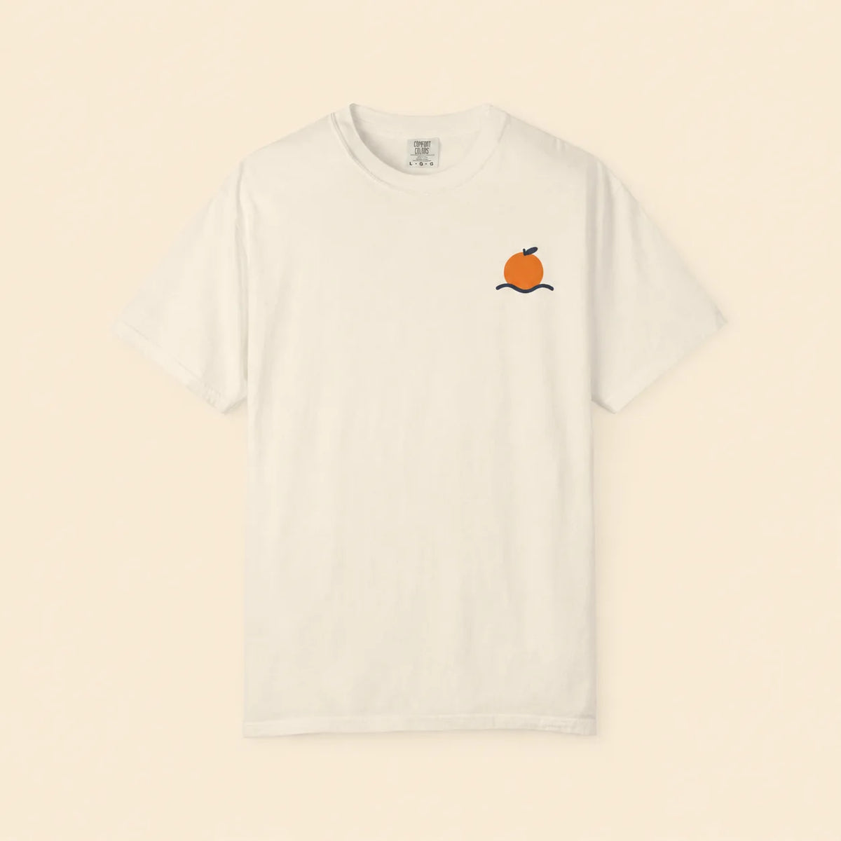 An off-white short-sleeve crewneck t-shirt featuring a small graphic of an orange on a black branch on the left chest, displayed against a solid cream background.