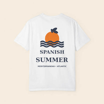 A white short-sleeve t-shirt shown flat against a light beige background. The back of the shirt features a graphic of an orange with a dark blue leaf, wavy blue lines, and the text 'SPANISH SUMMER' and 'MEDITERRANEAN • ATLANTIC' in dark blue.