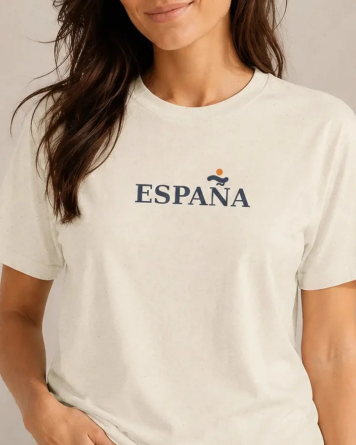 Natural unisex T-shirt featuring the minimalist España Essential front design with navy “ESPAÑA” lettering and a small orange sun-and-wave emblem.