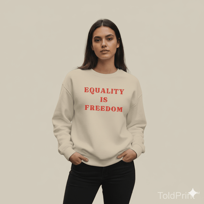 Person wearing a beige sweatshirt with 'EQUALITY IS FREEDOM' text in red on a plain background