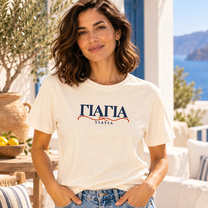 YIAYIA Natural T-shirt on female model in a Mediterranean courtyard
