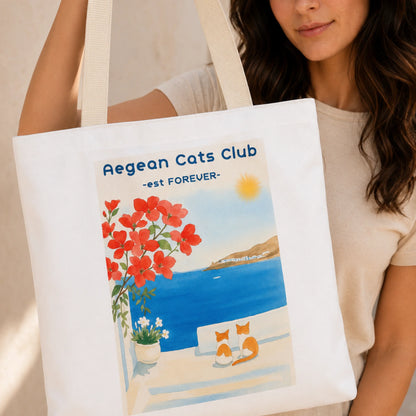 TP HERO: Person holding a tote bag with Aegean Cats Club design featuring cats by a beach.