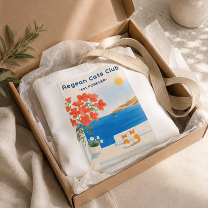 White tote bag with 'Aegean Cats Club' design in a brown box