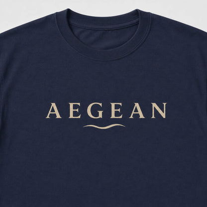 A close-up of a navy blue crewneck t-shirt featuring the word 'AEGEAN' printed in a beige serif font across the chest, with a small wavy line underneath.