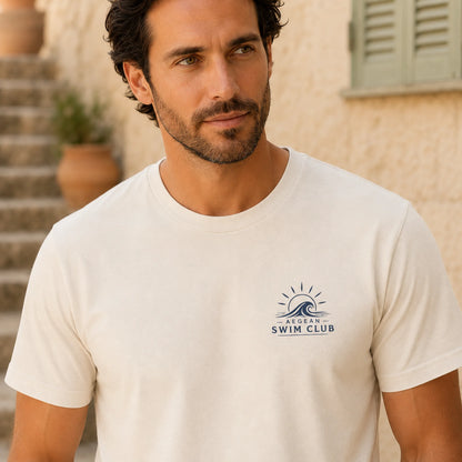 Man wearing a white t-shirt with a logo in an outdoor setting