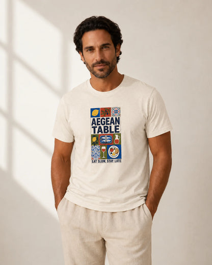 Man wearing a white t-shirt with 'Aegean Table' design against a neutral background