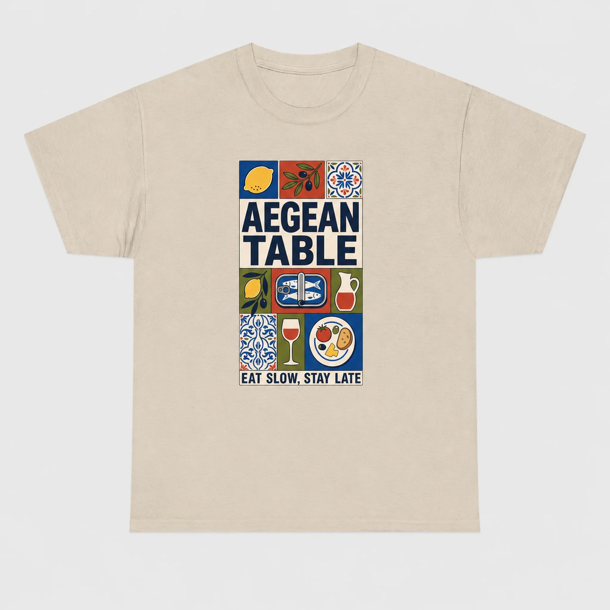 Beige t-shirt with 'Aegean Table' graphic design on a white background
