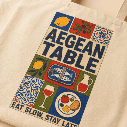 Beige tote bag with 'Aegean Table' design featuring food illustrations and text.