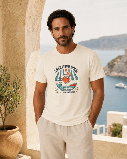 Man wearing a white t-shirt with a graphic design, standing in a scenic location with a view of the sea.