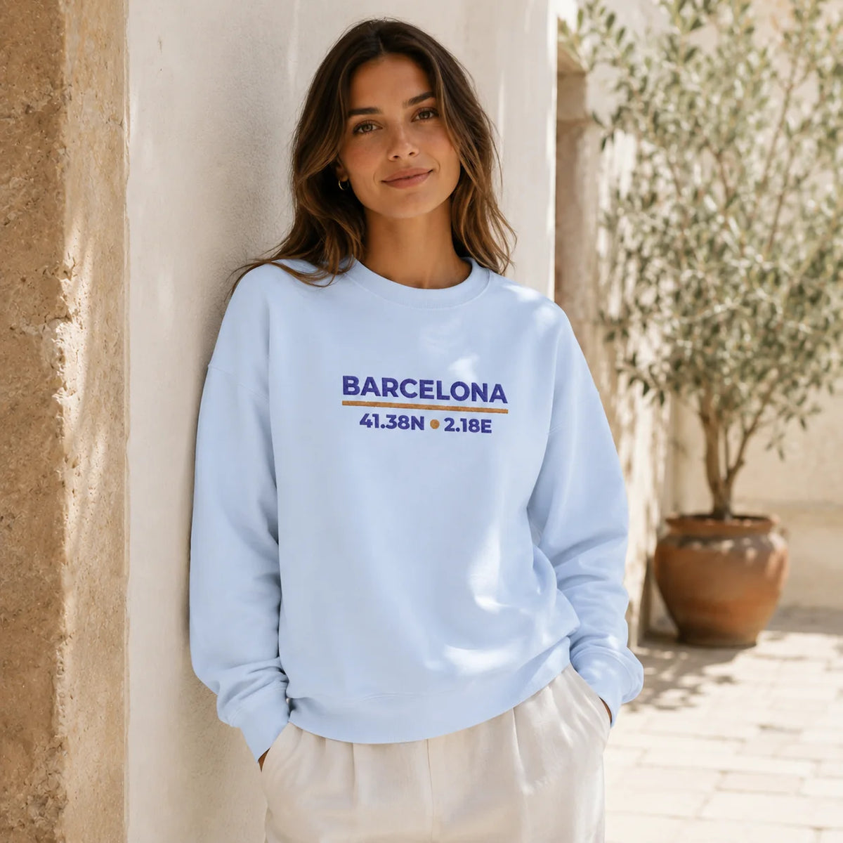 Female model wearing the Light Blue Barcelona Coordinates Embroidered Sweatshirt, showing the embroidered front design.
