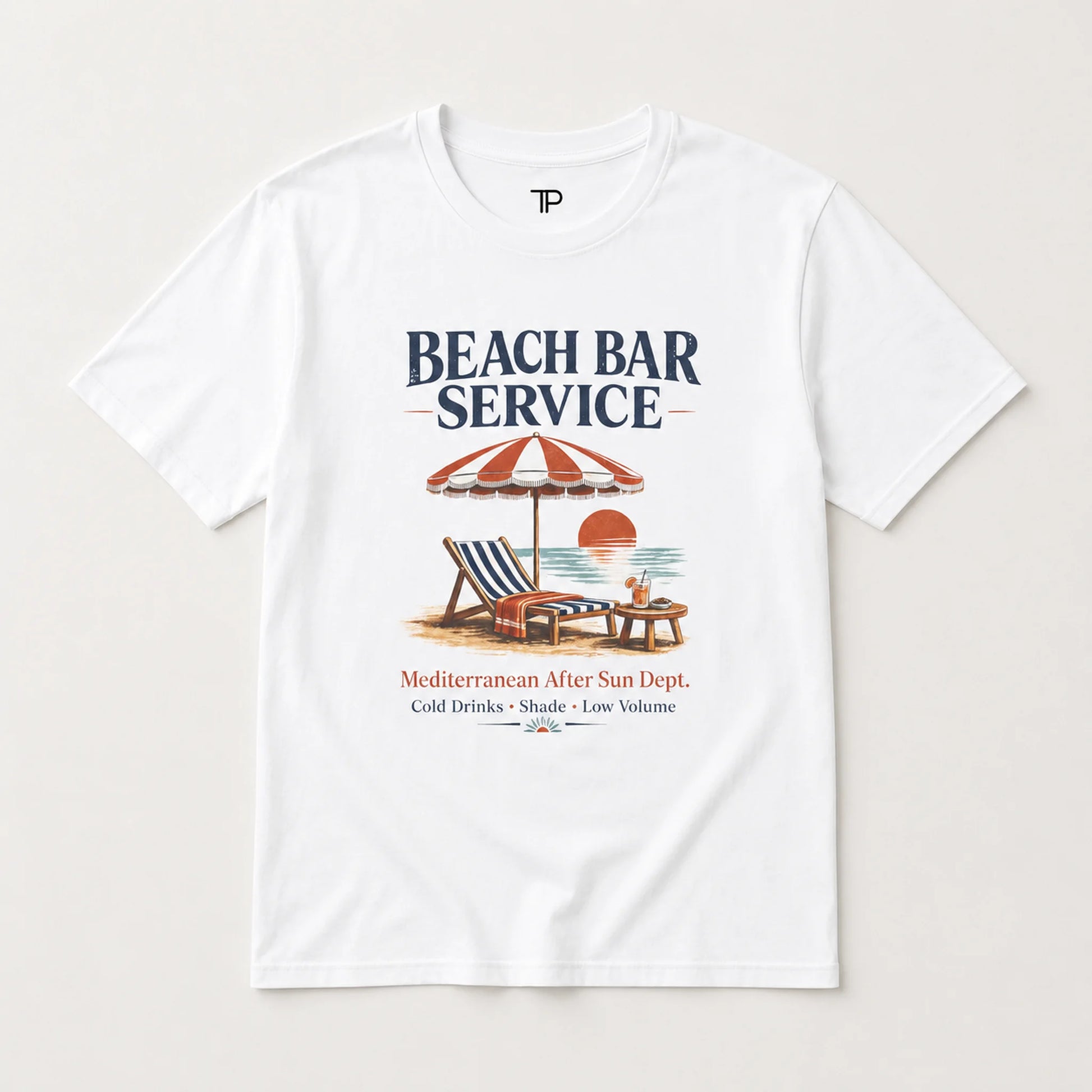 A white short-sleeve crewneck t-shirt featuring a retro-style graphic print of a beach bar scene with the text 'BEACH BAR SERVICE' and a vintage illustration of a striped umbrella, lounge chair, and sunset.