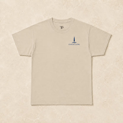 Flat lay of a sand t-shirt with 'Coastal Living' design
