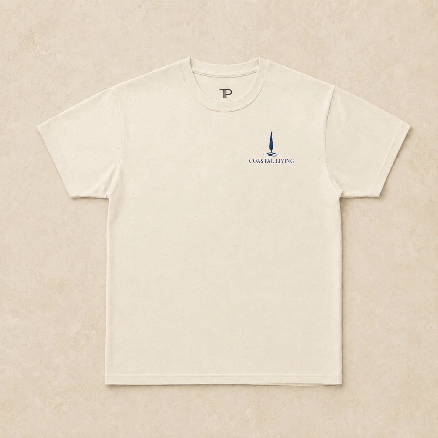 Flat lay of natural t-shirt with 'Coastal Living' design