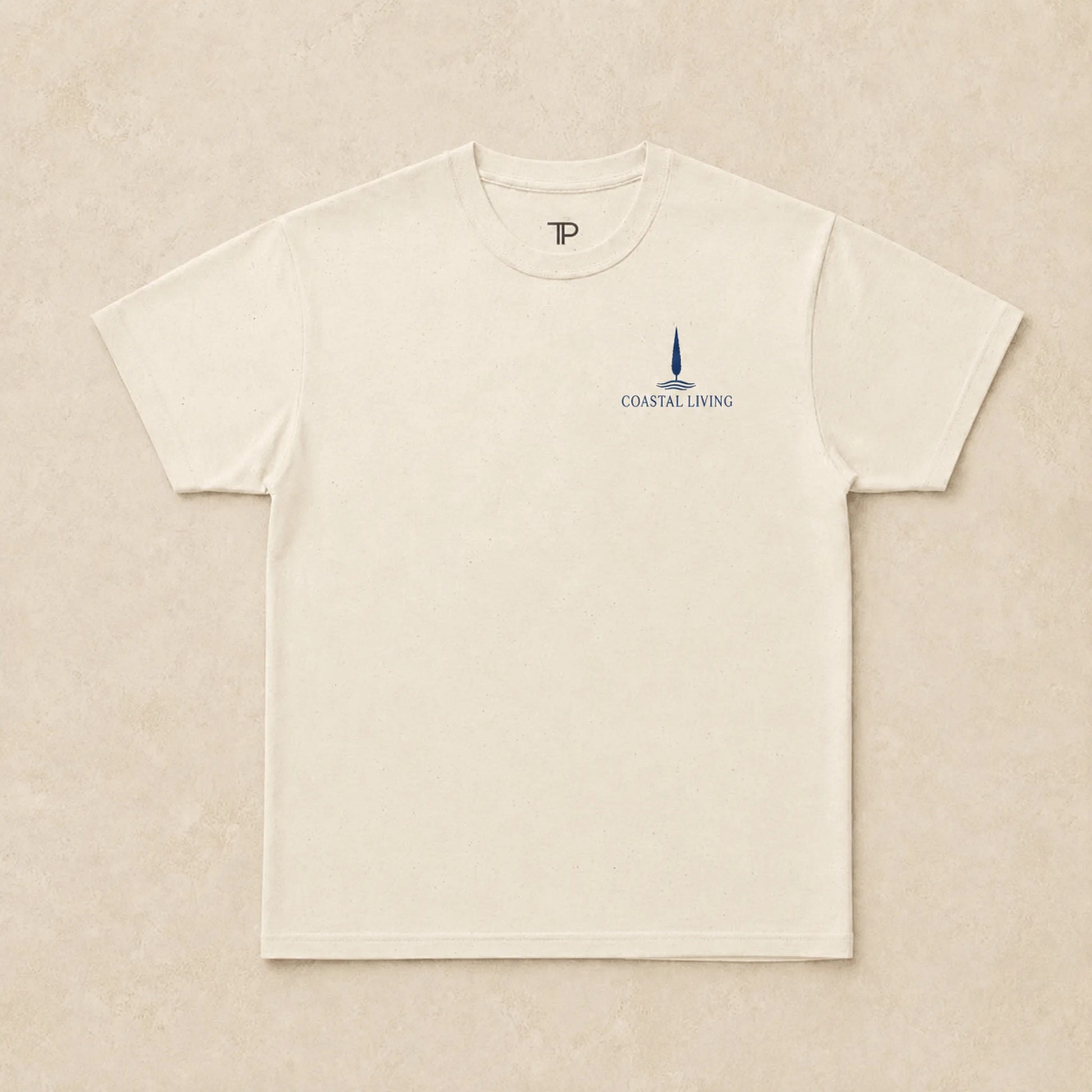 Flat lay of natural t-shirt with 'Coastal Living' design