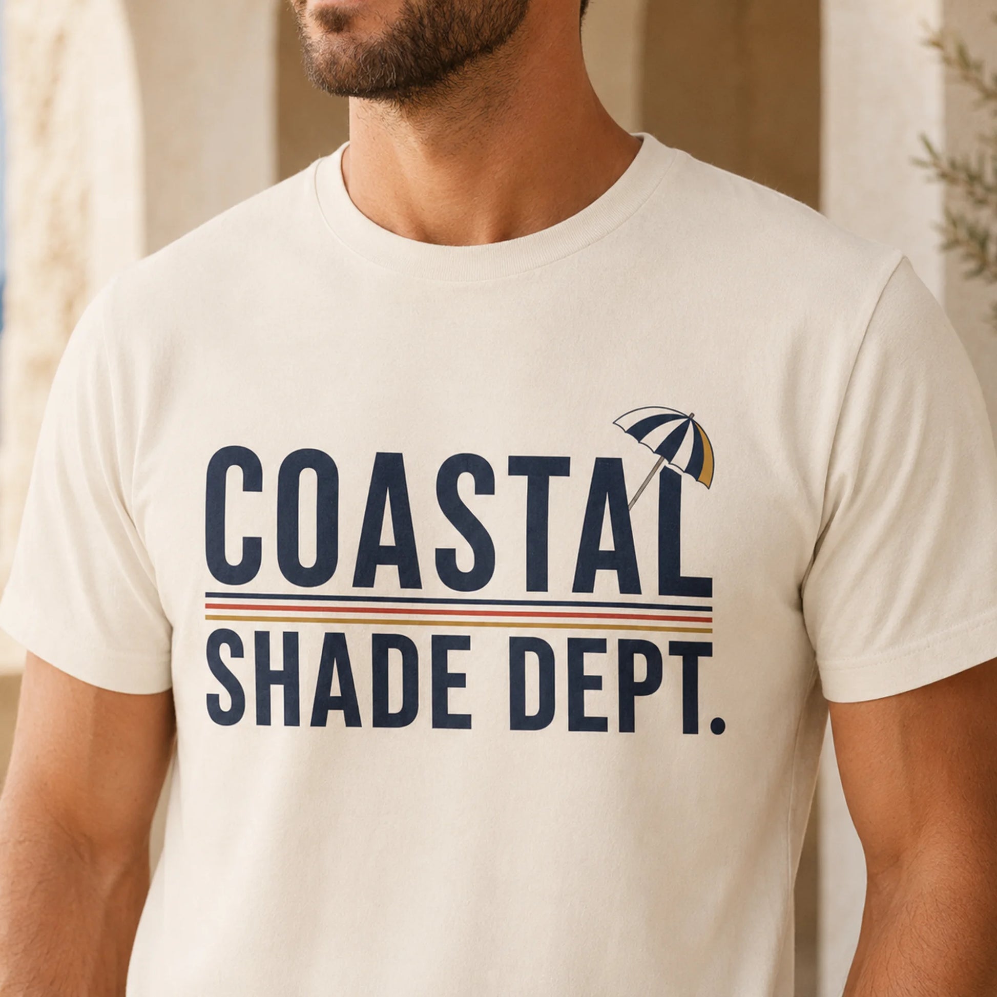 TP HERO: Man wearing ivory Coastal Shade Dept graphic T-shirt in a sunlit Mediterranean setting