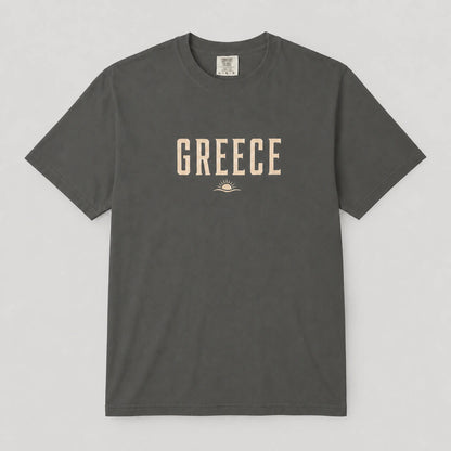 A dark gray crewneck t-shirt with 'GREECE' printed in beige block letters and a small sun graphic on the chest, displayed flat against a light gray background.