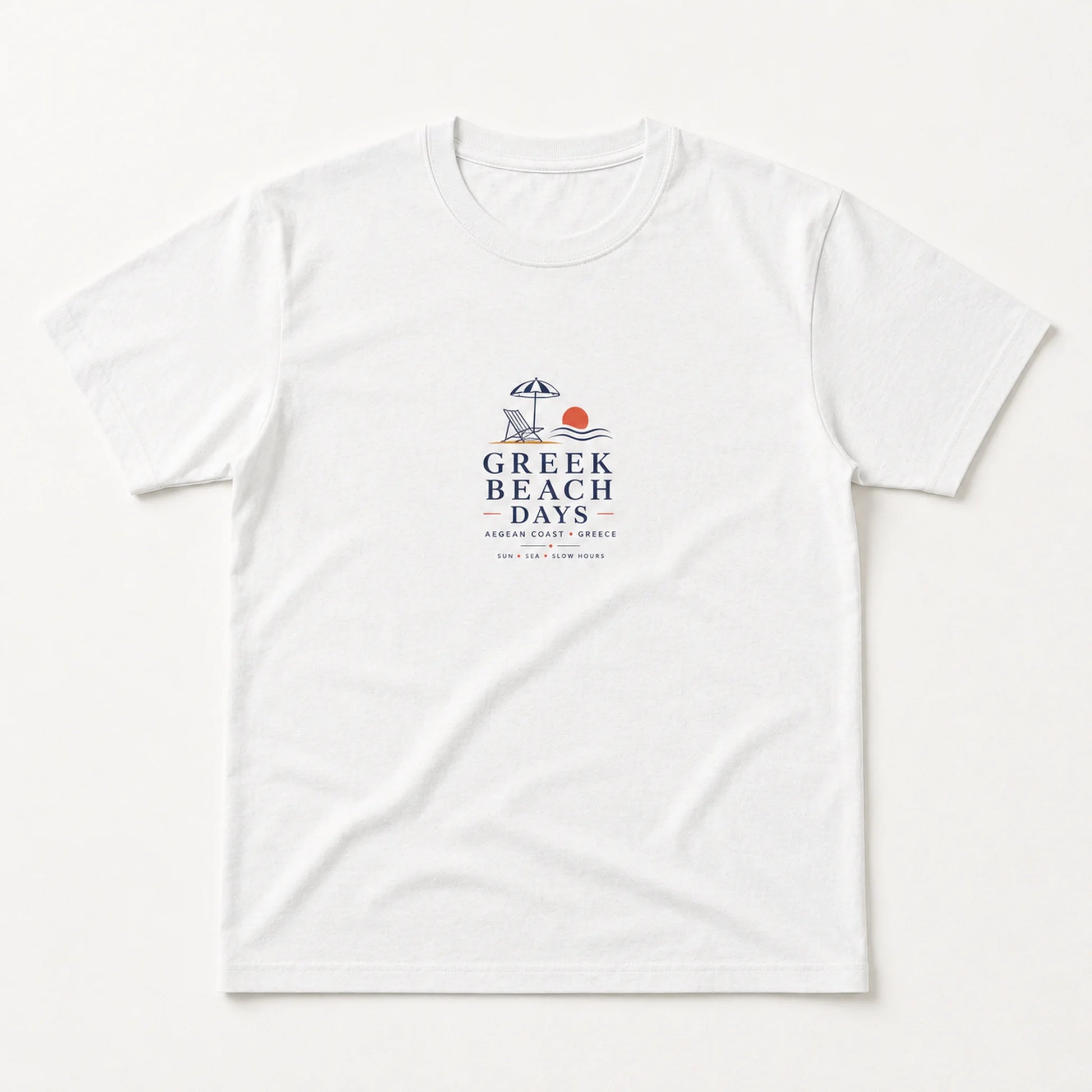 A white short-sleeve crewneck t-shirt with a 'Greek Beach Days' graphic printed on the center chest, displayed flat against a clean white background.
