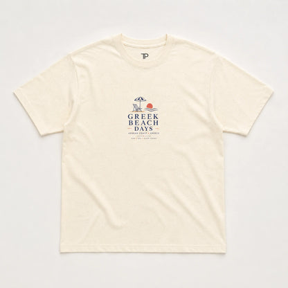 An off-white short-sleeve crewneck t-shirt with a 'Greek Beach Days' graphic printed on the chest, laid flat against a light background.